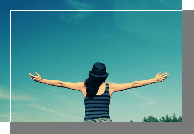 A woman with her arms outstretched in front of the sky.