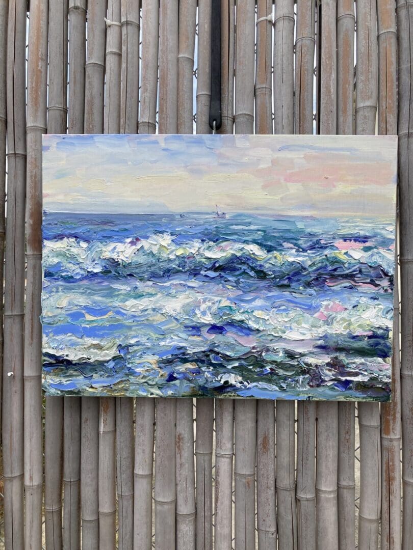 A painting of the ocean waves on a bamboo fence