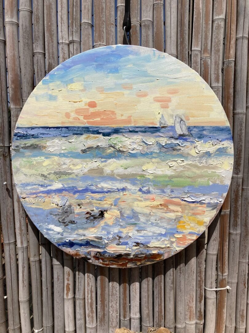 A painting of the ocean on a round canvas.